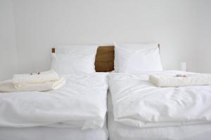 two beds with white sheets and towels on them at Cozy Apartment with private parking in Piešťany