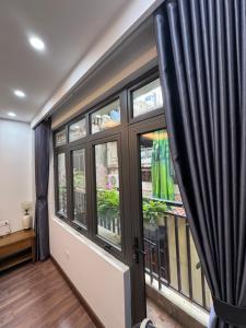 a room with a window with black curtains at 54 homestay Van Mieu in Hanoi +16 photos