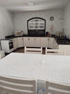 a kitchen with a white table in a room at Casa com piscina proximo da praia in Itapoa