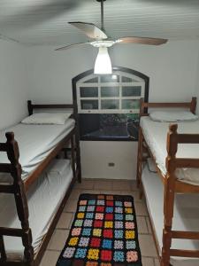 a room with two bunk beds and a rug on the floor at Casa com piscina proximo da praia in Itapoa