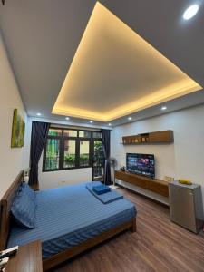 a bedroom with a large bed and a tv at 54 homestay Van Mieu in Hanoi