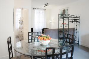 a glass dining room table with a bowl of flowers on it at Appartement Avec Terrasse in Honfleur