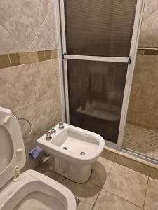 a small bathroom with a toilet and a shower at LUMINOSO Y COMPLETO DEPARTAMENTO CENTRO Villa Carlos Paz in Villa Carlos Paz +7 photos
