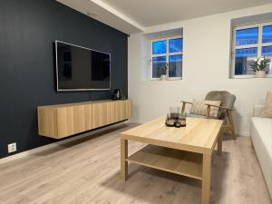 波多Perfect base in the middle of the city!的客厅配有桌子,墙上配有电视