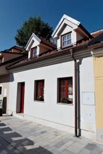 a white house with red windows and a roof at Apartment U Karla in Třeboň