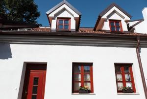 a white house with red windows and a roof at Apartment U Karla in Třeboň