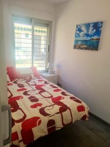 a bedroom with a bed with a red and white comforter at Casa Albatros in Santa Pola +5 photos