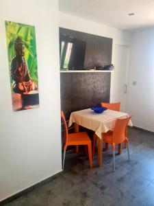 a dining room with a table and orange chairs at Casa Albatros in Santa Pola
