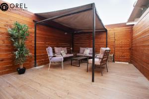 a covered patio with chairs and a table and a plant at orel's Top apartment in Eilat