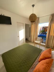 a bedroom with a large green bed and a window at Hostel Killamoon Centro in Paracas