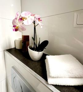 a bathroom with a black counter with pink flowers on it at 2 Zimmer Wohnung für 2 in Mülheim an der Ruhr +15 photos