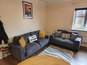 a living room with a couch and a table at SAV Stays Apartments Watford in Watford +2 photos