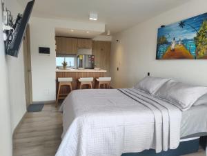 a bedroom with a bed and a kitchen at Apartamento Turístico Santa Marta punta gaira in Santa Marta