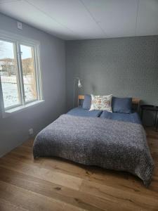 ein Schlafzimmer mit großem Bett und Fenster in der Unterkunft Sea Breeze Cottage in Färjestaden