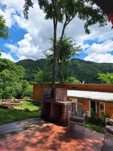 a house with a tree and a bench in front at Mis Cabañas La Misión in Salta