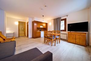 a living room with a table and a television at Con Parking y Escritorio I Apartamento en Incles I AndBnB in Canillo