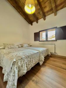 a bedroom with a bed with a white comforter at Casa del Horno in Viniegra de Arriba