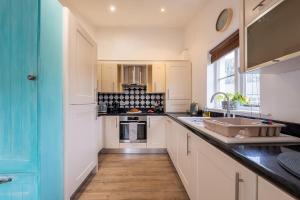 una cucina con un lavello e un bancone di Spacious & relaxing cottage stay with free parking a Cark