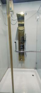 a glass shower door with a blender on a wall at Cilantro Agonda in Agonda