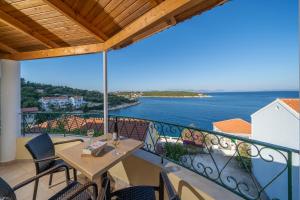 a balcony with a table and chairs and the ocean at Stella Hotel Apartments in Fiskardo