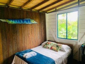 a small bed in a room with a fish on the wall at Majagua in Bahía Solano