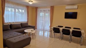 ein Wohnzimmer mit einer Couch und einem Tisch und Stühlen in der Unterkunft Levendula Vendégház in Nyírmeggyes