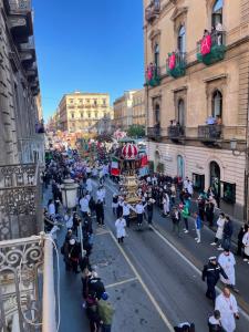Una folla di persone che guarda una parata in una citta' di Catammari a Catania