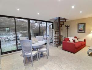 a living room with a table and a red couch at La bonne adresse de Provence in Cornillon-Confoux