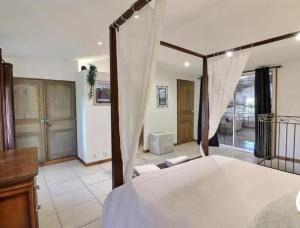 a bedroom with a bed with a canopy at La bonne adresse de Provence in Cornillon-Confoux +27 photos