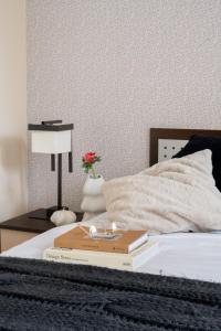 łóżko z książką i kwiatem w obiekcie Apartamenty Tetmajera APARTZAKOP w Zakopanem