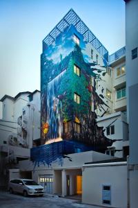
a painting of a building with a clock on it at Hotel Clover The Arts (SG Clean) in Singapore
