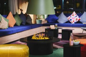 a living room with couches and a table with flowers on it at Moxy Annecy in Annecy