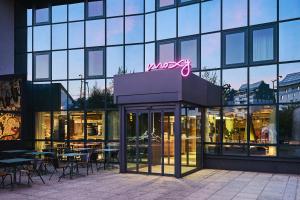 a restaurant with tables and chairs in front of a building at Moxy Annecy in Annecy