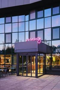a building with a neon sign on top of it at Moxy Annecy in Annecy