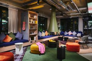 a living room with colorful couches and chairs at Moxy Annecy in Annecy