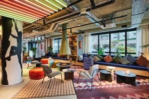 an office lobby with colorful furniture and windows at Moxy Annecy in Annecy