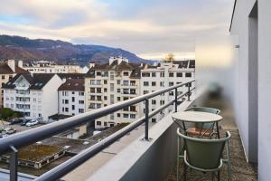 a balcony with a table and chairs and buildings at Moxy Annecy in Annecy