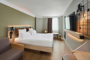 a bedroom with a large white bed and a couch at Moxy Annecy in Annecy