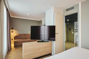 a living room with a large flat screen tv at Moxy Annecy in Annecy