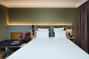 a bedroom with a large bed with white pillows at Moxy Annecy in Annecy