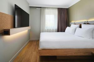 a hotel room with a bed and a flat screen tv at Moxy Annecy in Annecy