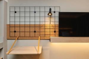 a light hanging from a wall next to a bench at Moxy Annecy in Annecy