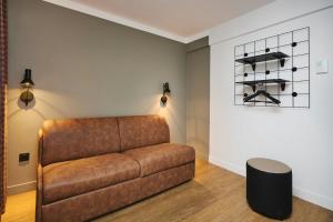 a living room with a brown couch and a table at Moxy Annecy in Annecy