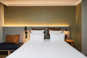 a bedroom with a large bed with white pillows at Moxy Annecy in Annecy