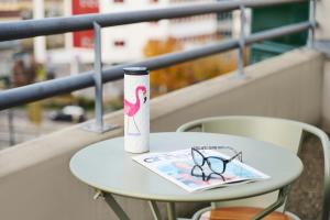 a table with a drink bottle and a book on it at Moxy Annecy in Annecy