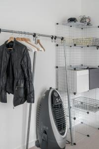 a leather jacket hanging on a rack next to a fan at Waterview apartments with ultra fast wifi close to Excel and O2, corporates and contractors welcome in London