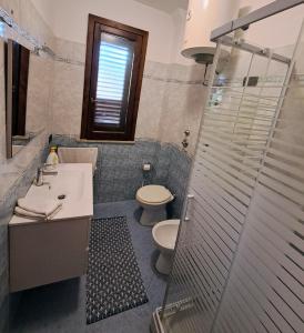 a bathroom with a toilet and a sink and a shower at Casa Isulidda in San Vito lo Capo +19 photos
