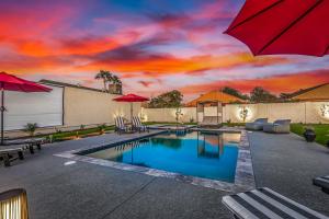 una piscina en un patio trasero con puesta de sol en NEW - The Palmcroft Golf Escape, en Scottsdale