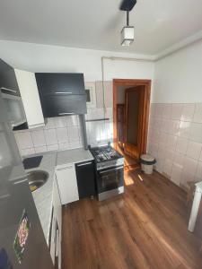 a kitchen with a stove and a wooden floor at Apartament Gabriela in Vulcan +7 photos