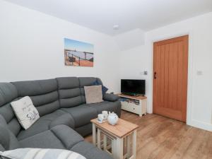 Una sala de estar con un sofá gris y una mesa. en 6 Malthouse Court, en Saint Decumans